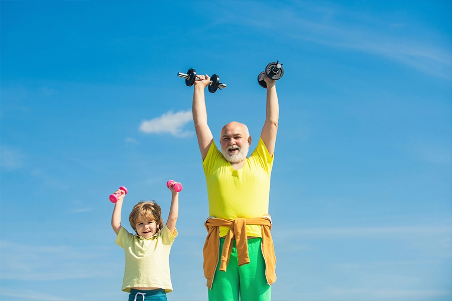 Senior man and child exercising on blue sky. 